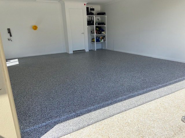 A photo taken at the front of a double garage showing the new Resin Vinyl epoxy flake floor inside.