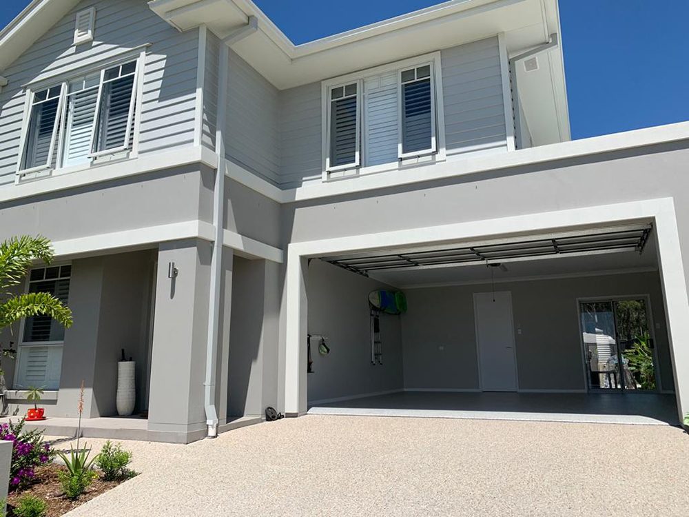 A wide-angle photo of a home garage with the door open showing the new Resin Vinyl epoxy flake floor.