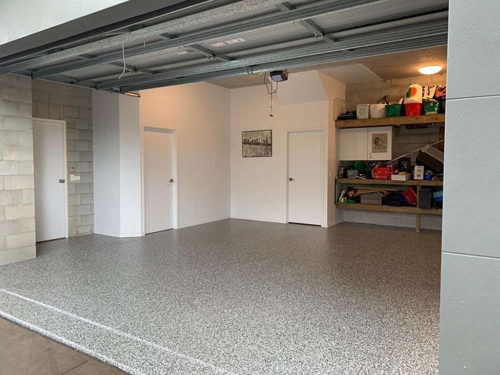 A home garage with the door open showing the new Resin Vinyl epoxy flake floor.