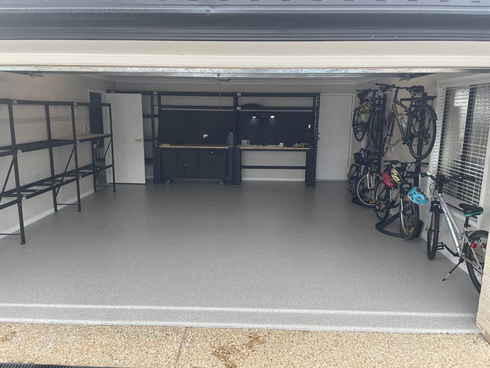 A home garage with the door open showing the new Resin Vinyl epoxy flake floor.